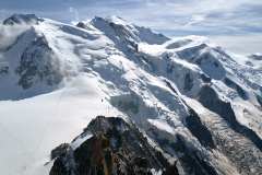 Aiguille du Midi, utsikt mot Mont Blanc. Refuge des Cosmiques i förgrunden, två klättrare på glaciären