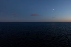 Tidig morgon med måne över havet